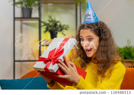 Happy child girl kid hold birthday gift box with ribbon, celebrating party, opening present at home Happy child girl kid hold birthday gift box with ribbon, celebrating party, opening present at home 116486513