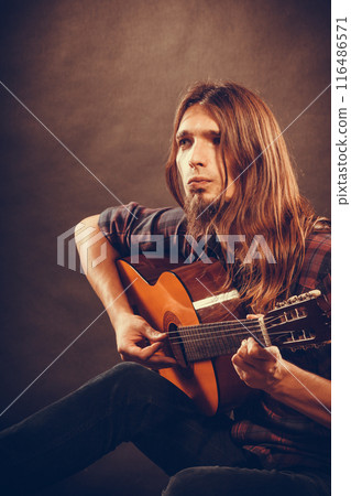 Young man is thinking about new song. 116486571