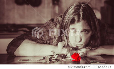 Worried man with rose and mobile phone. Worried man with rose and mobile phone. 116486573