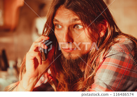 Worried man talking on mobile phone. Worried man talking on mobile phone. 116486574