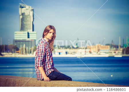 Man long hair relaxing by seaside Man long hair relaxing by seaside 116486601