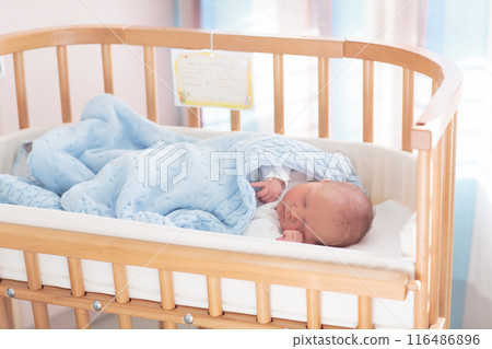 Newborn baby boy in hospital cot Newborn baby boy in hospital cot 116486896