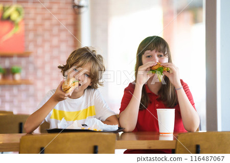 Kids eating fastfood. Unhealthy junk food. Kids eating fastfood. Unhealthy junk food. 116487067