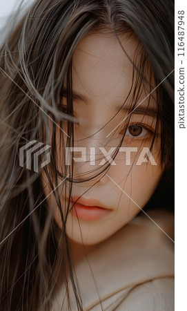 Close-Up Portrait of a Young Woman With Windswept Hair Covering Her Face 116487948