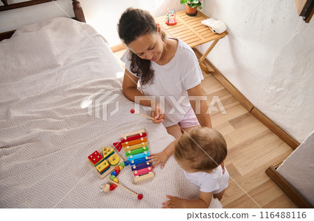 Mother and toddler playing with educational toys in a cozy bedroom setting Mother and toddler playing with educational toys in a cozy bedroom setting 116488116
