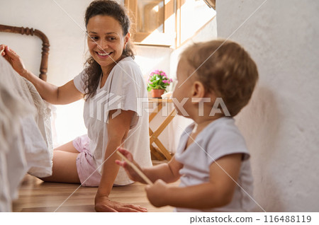 Happy mother and child enjoying quality time at home on a sunny morning indoors Happy mother and child enjoying quality time at home on a sunny morning indoors 116488119