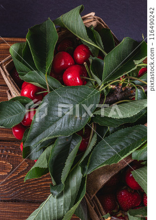 ripe cherries in a box on the table close up top view 116490242
