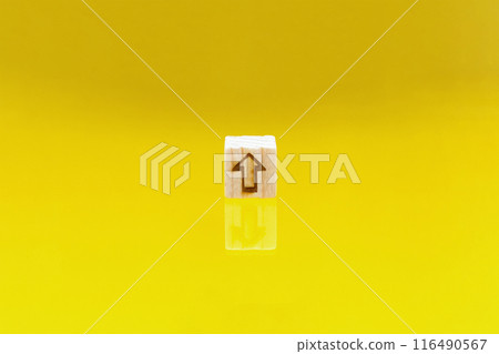 A yellow background with an upward arrow mark block reflected on the floor A yellow background with an upward arrow mark block reflected on the floor 116490567