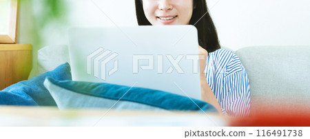 A woman who plays a personal computer in the living room 116491738