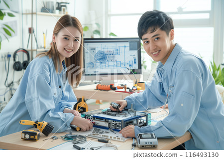 Male and female engineers disassembling and maintaining a computer_1 116493130