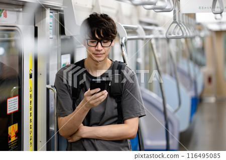 Man looking at smartphone on train Man looking at smartphone on train 116495085