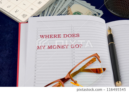 words Where does my money go. Business concept in a business notebook in a composition with money, glasses, a fountain pen and parts of a calculator 116495545