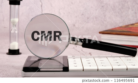 Customer Managed Relationship Concept. CMR word through a magnifying glass on a gray wall, front view 116495691
