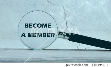 The inscription BECOME A MEMBER through a magnifying glass on the wall. Photos in cold colors 116495695