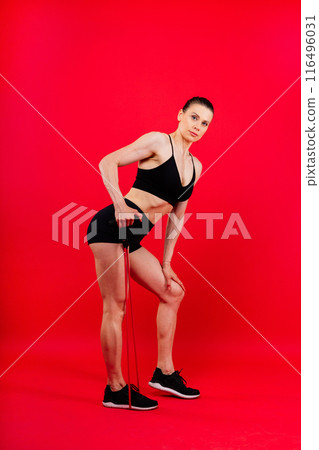 Athletic female performs exercises using a resistance band. Strength and motivation 116496031