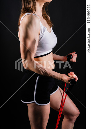 Athletic female performs exercises using a resistance band. Strength and motivation Athletic female performs exercises using a resistance band. Strength and motivation 116496061