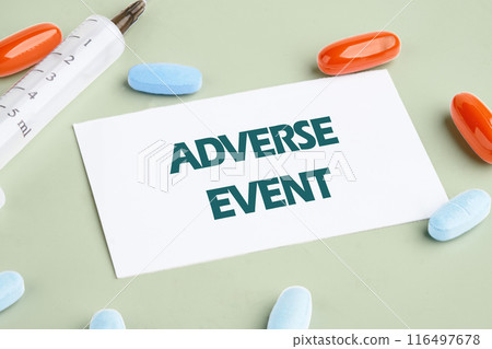 Medicine concept. ADVERSE EVENT written on a white business card with a syringe and pills lying next to it 116497678
