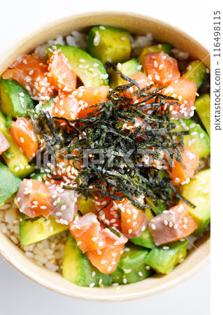 poke bowl with diced raw salmon fish and avocado on sushi rice in paper container. 116498115