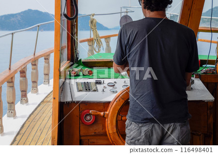 The captain of the ship at the helm The captain of the ship at the helm 116498401