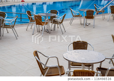 Metal tables and chairs with wicker seats in outdoor cafe. Metal tables and chairs with wicker seats in outdoor cafe. 116498516