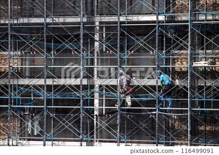 在大規模維修工作期間,作為安全措施的臨時鷹架施工,導致大型公寓被鷹架管和網片覆蓋。 在大規模維修工作期間,作為安全措施的臨時鷹架施工,導致大型公寓被鷹架管和網片覆蓋。 116499091