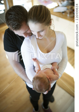 New parents holding newborn baby girl. Unconditional paternal love, idyllic family moment. 116499634