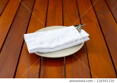 knife with fork and spoon in napkin on white plate 116501130