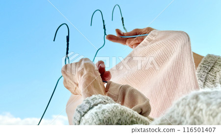 Elderly woman's hands taking in laundry_wide Elderly woman's hands taking in laundry_wide 116501407