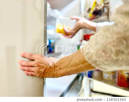 老婦人的手從冰箱拿出一箱食物 116501563