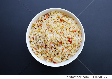 Cooked brown rice in a bowl on dark background. Cooked brown rice in a bowl on dark background. 116501770