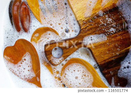 Wooden kitchenware in water and bubbles of dishwashing liquid Wooden kitchenware in water and bubbles of dishwashing liquid 116501774
