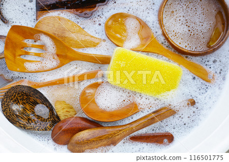 Wooden kitchenware in water and bubbles of dishwashing liquid Wooden kitchenware in water and bubbles of dishwashing liquid 116501775