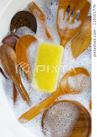 Wooden kitchenware in water and bubbles of dishwashing liquid Wooden kitchenware in water and bubbles of dishwashing liquid 116501776