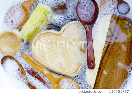 Wooden kitchenware in water and bubbles of dishwashing liquid 116501777