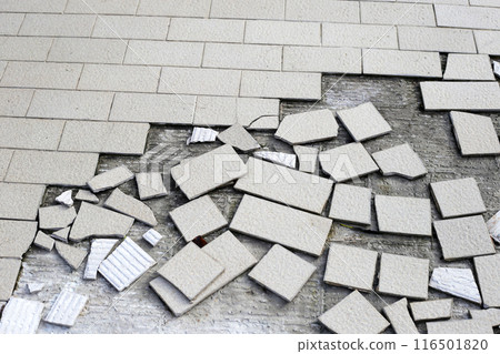 Cracked brown tiles on cement floor 116501820