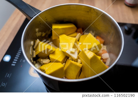 Chef at the kitchen preparing pumpkin porridge with tofu and vegetables Chef at the kitchen preparing pumpkin porridge with tofu and vegetables 116502190