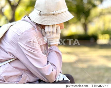 Elderly woman resting her chin in the park Elderly woman resting her chin in the park 116502235