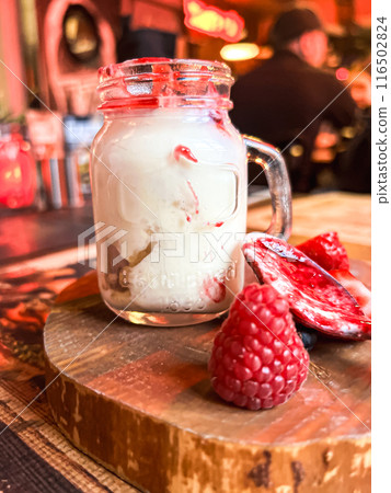 Mason jar with ice cream and fresh raspberries on wooden table. Delicious yogurt with fresh berries in a jar  116502824