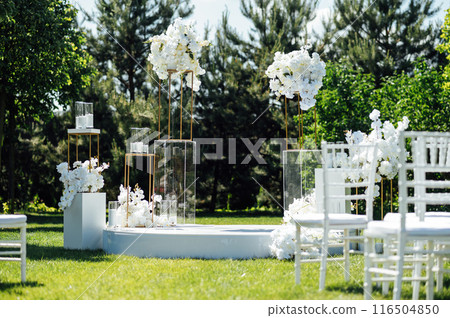 Wedding ceremony. Very beautiful and stylish wedding arch, decorated with various fresh flowers, standing in the garden. Wedding ceremony. Very beautiful and stylish wedding arch, decorated with various fresh flowers, standing in the garden. 116504850