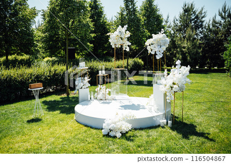 Wedding ceremony. Very beautiful and stylish wedding arch, decorated with various fresh flowers, standing in the garden. Wedding ceremony. Very beautiful and stylish wedding arch, decorated with various fresh flowers, standing in the garden. 116504867