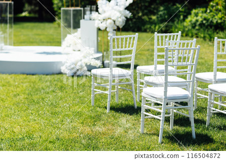 Wedding ceremony. Very beautiful and stylish wedding arch, decorated with various fresh flowers, standing in the garden. Wedding ceremony. Very beautiful and stylish wedding arch, decorated with various fresh flowers, standing in the garden. 116504872