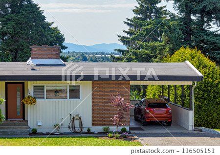 Average family house with mountain view and red car parked under the carport 116505151