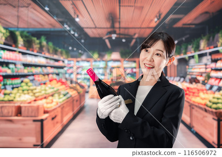 Female sommelier holding wine Female sommelier holding wine 116506972