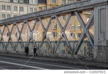 People walking along a Bridge on Rue La Fayette. Bridge built above the railways of gare de l'Est. People walking along a Bridge on Rue La Fayette. Bridge built above the railways of gare de l'Est. 116507023