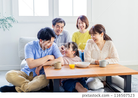 Three-generation family relaxing in the living room 116507523