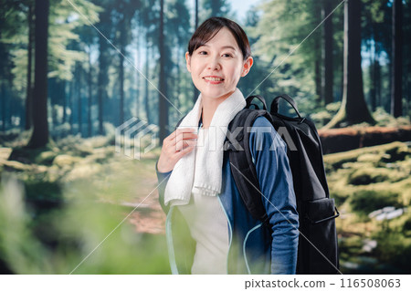 Woman climbing a mountain in sunny weather Woman climbing a mountain in sunny weather 116508063