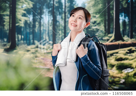 Woman climbing a mountain in sunny weather Woman climbing a mountain in sunny weather 116508065