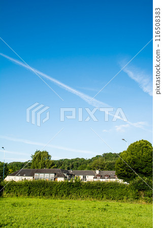 南威爾斯深藍天空留下的軌跡，明亮的陽光照亮了田野和歷史悠久的房屋 116508383