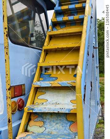 A set of stairs with yellow and blue colors ascending towards on a old bus roof A set of stairs with yellow and blue colors ascending towards on a old bus roof 116508445