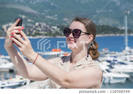 Young Woman Taking Selfie at Scenic Mediterranean Marina 116508549